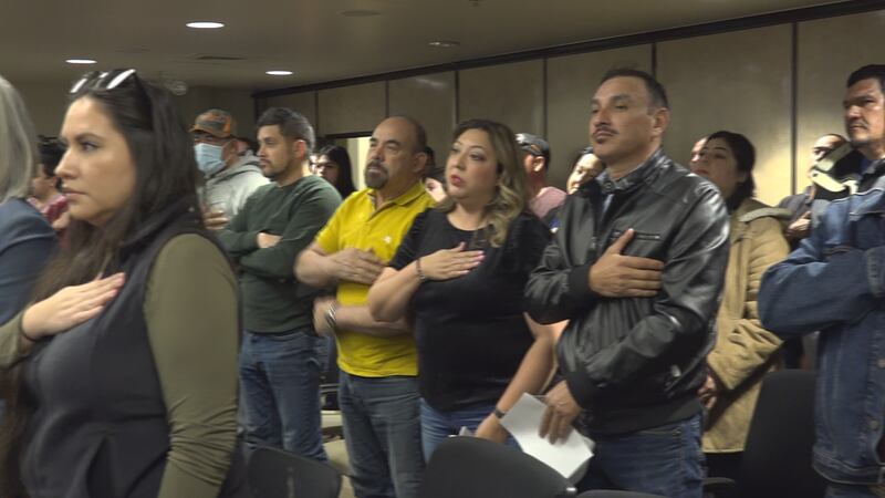 Community members say the pledge at the meeting